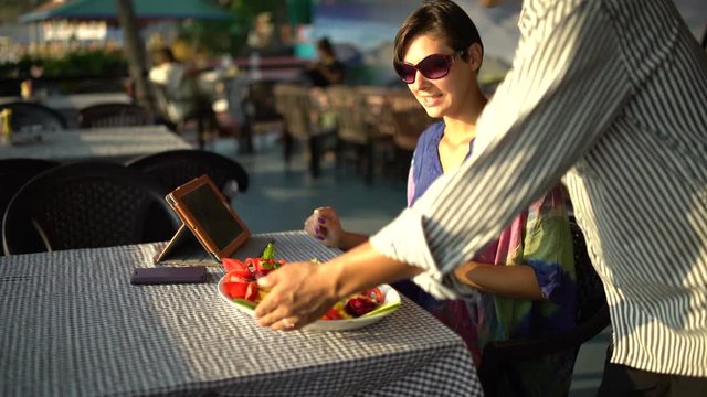 The waiter brings a dish of food