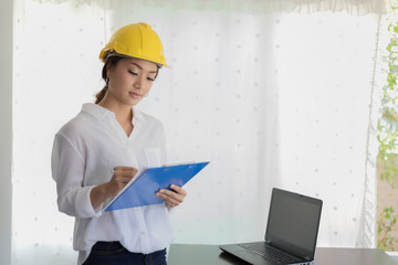  Asian women engineering inspecting and working and holding blueprints at office