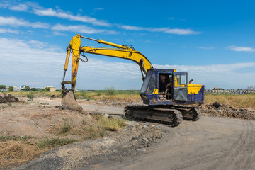 Fototapeta na wymiar construction site with dirty yellow excavator during work
