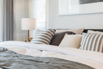 set of pillows and blanket on bed in modern bedroom