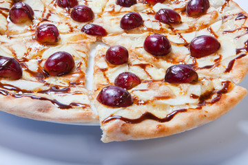 sweet apple pizza with sliced grape on white background