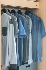 Obraz premium clothes hanging on rail in wooden wardrobe