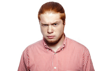 doubting confused bearded readhead businessman with red shirt and freckles looking at camera. studio shot isolated on white.