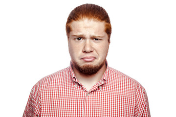Sad unhappy bearded readhead businessman with red shirt and freckles looking at camera. studio shot isolated on white.