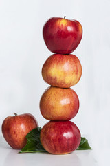 pyramid of four red apples on white