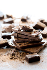Pile of dark and milk chocolate block Vertical photo Chopcolate candy on background