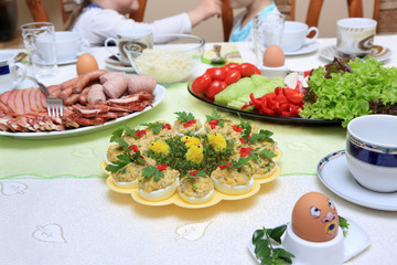 Śniadanie Wielkanocne na stole, wędliny, pieczeń i jajka.
