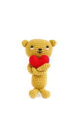 crochet doll of a bear holding a red heart, concept of love and romantic for Valentine's day or happy anniversary.