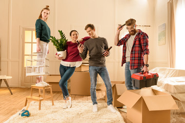 friends holding different things for moving into new house