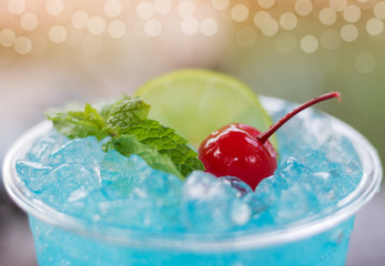 Close up blue hawaii Italian soda with cherry and mint.