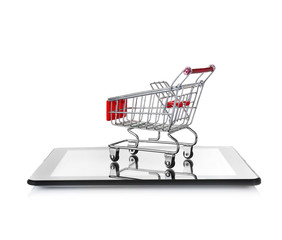 Online shopping concept. Tablet with mini market trolley on white background