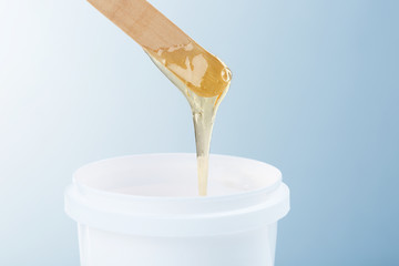Wooden stick with sugaring paste on light background