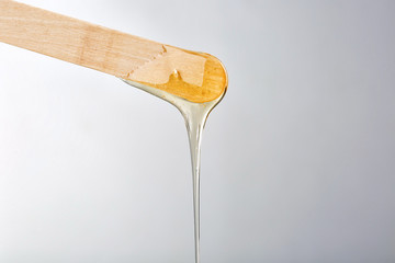 Wooden stick with sugaring paste on light background