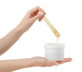 Female hands with wooden stick and sugaring paste on light background