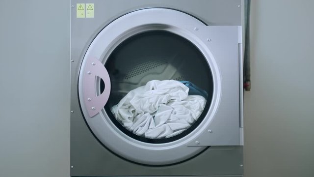 Industrial washing machine washing clothes. Laundry machine working. Industrial machine washing clothing. Laundry washing machine. Industry laundry service