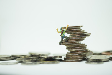 Miniature climbers team climbing on stack of coins. Business finance, challenging, compitition concept.