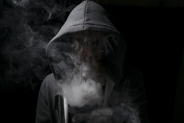 vaping man wearing a hoody with lots of smoking clouds.