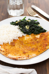 fried turkey with rice and spinach on the dish