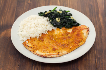 fried turkey with rice and spinach on the dish