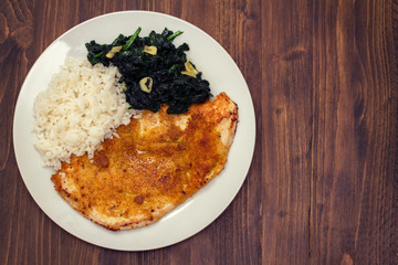 fried turkey with rice and spinach on the dish