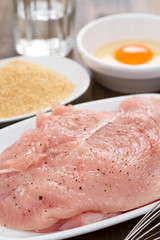 raw turkey, dry bread and egg on wooden background