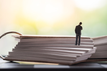 Miniature people standing on book using as background education or business concept.