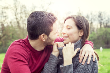 nice couple boyfriends relaxing and kissing on meadow outdoor