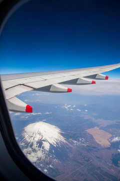 Fototapeta view of fuji mountain and wing of the air plane  from window airplane with Aerial view background, Yamanashi, Japan