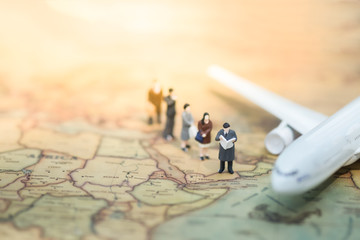 Fototapeta na wymiar Miniature people : group of businessman passenger standing on world map in front of airplane waiting for boarding, business concept, exploring on earth background concept.