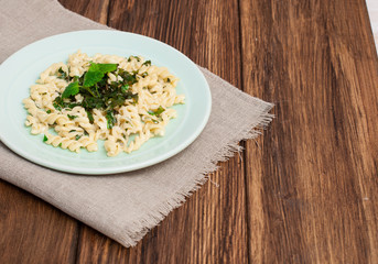 Pasta with pesto sauce, on a wooden background. Italian food.