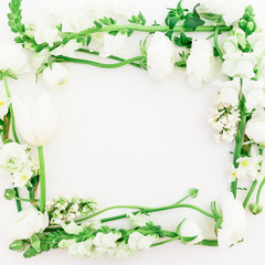 Frame of white ranunculus, snapdragon, lilac and tulip on white background. Flat lay, top view.