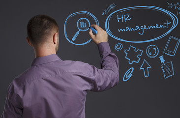 Business, Technology, Internet and network concept. A young businessman writes on the blackboard the word: HR management
