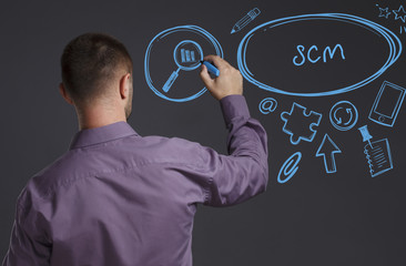 Business, Technology, Internet and network concept. A young businessman writes on the blackboard the word: SCM