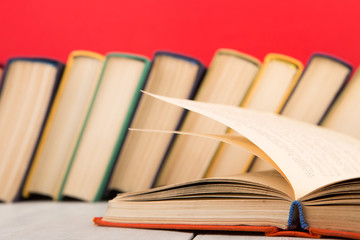 education and wisdom concept - open book on wooden table, color background