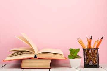 education and wisdom concept - open book on wooden table, color background