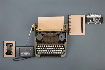 Journalist or private detective workplace - typewriter, camera, recorder and other stuff