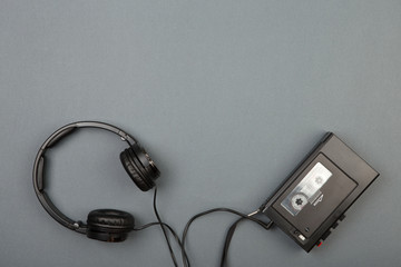 Retro cassette player with headphones on grey background