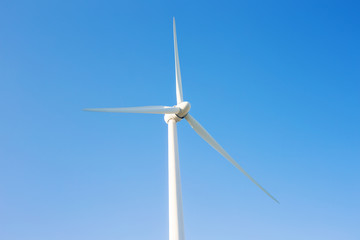 Wind turbine generating electricity with blue sky - energy conservation concept