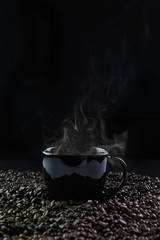 Black coffee cup with coffee and coffee beans with smoke