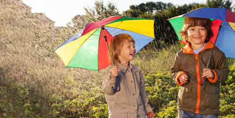 happy brother with umbrella outdoors