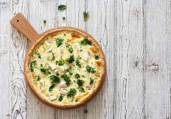 Vegetable pie ( quiche) with broccoli and soft cheese over white  background