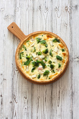 Vegetable pie ( quiche) with broccoli and soft cheese over white  background