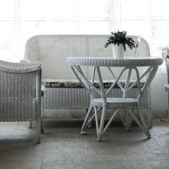 Empty cafe seating area with rattan table and chairs in cottage style