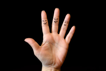 Smiling fingers of the hand on a black background. Funny abstract scene of the hand.
