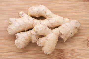 Powdered roots and ginger grated on wooden background