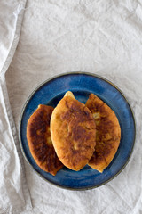 Traditional Homemade Baked Patties or Pies with Jam on blue dish. Fried Russian Pirozhki made from Yeast Dough in Rustic Style