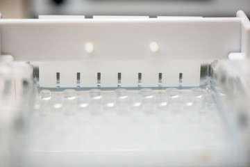 Close-up detail of a electrophoresis comb in an mold filled with agarose gel undergoing solidification. Molecular genetics and medical diagnosis technology concept.