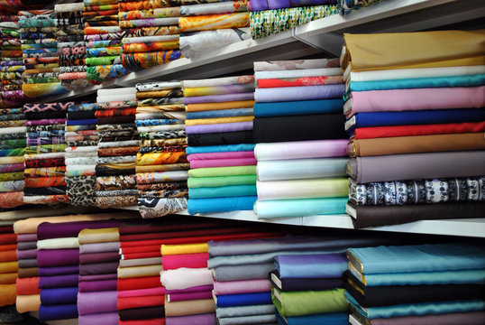 Heap of cloth fabric displayed on the shelves in a local store.