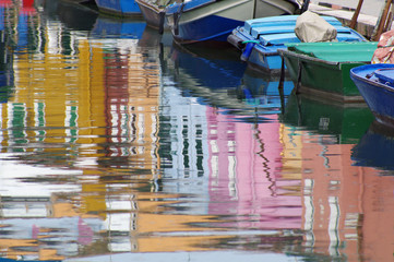 Fototapeta na wymiar Reflection bright colored houses on the surface of a channel.