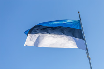 Waving Flag of Estonia, Blue, Black and White stripes isolated on blue sky background